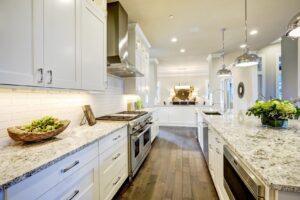 Kitchen with white cabinets, stainless steel appliances and white/gray countertops