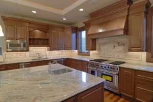 Big kitchen with wood cabinets, stainless steel appliances, and grey/white/tan countertops