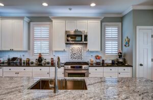 Modern kitchen with white cabinets and white/black/grey granite countertops