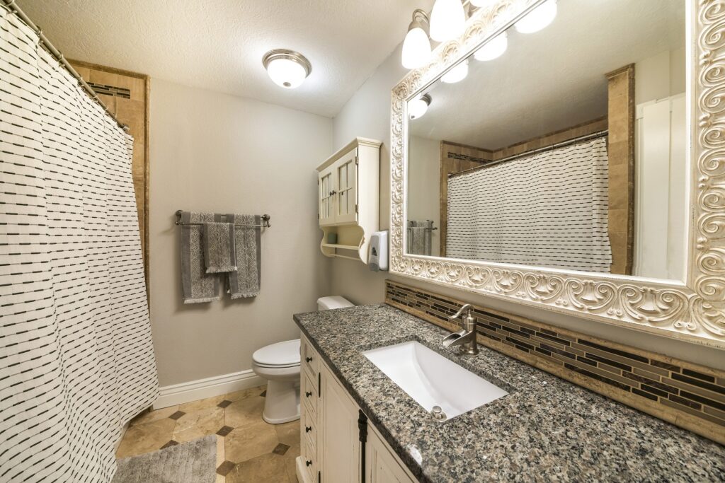 Traditional bathroom interior with limestone tiles and vanity unit with granite counter