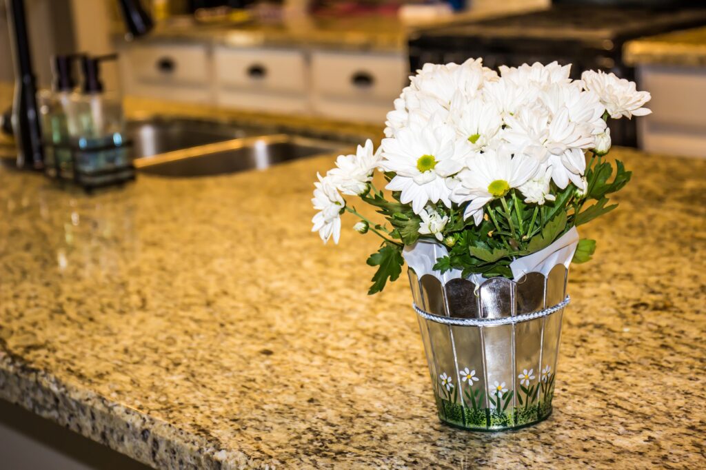 Silver Bucket With White Pansies On Granite Kitchen Counter