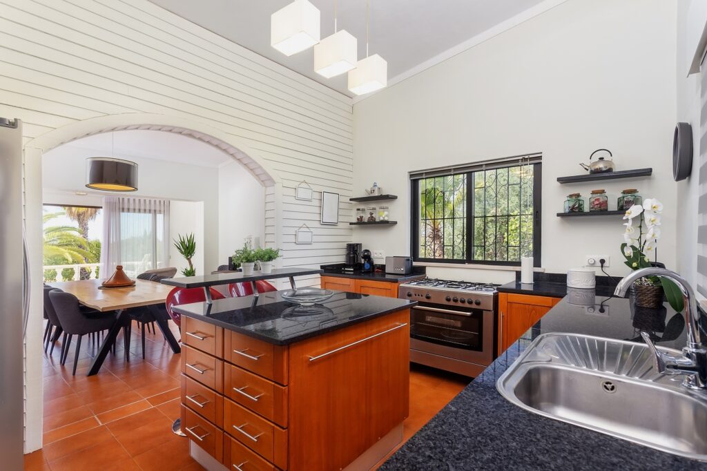 Modern bright kitchen, with a marble table and wooden pedestals