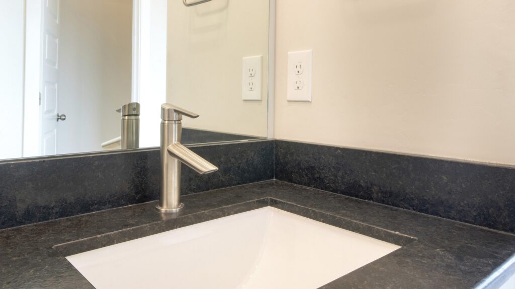 Bathroom sink with granite countertop and single faucet