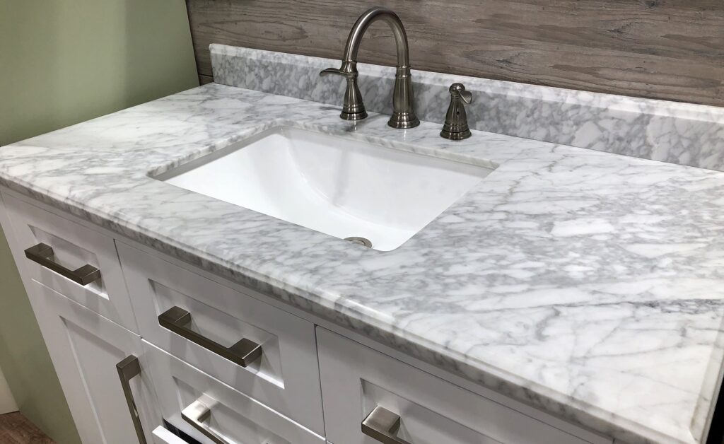 marble stone, marble countertop, bathroom vanity with marble countertop, white cabinets under marble countertops, white sink under marble counter